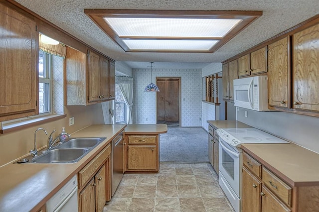 kitchen with white appliances, wallpapered walls, a peninsula, a sink, and light countertops