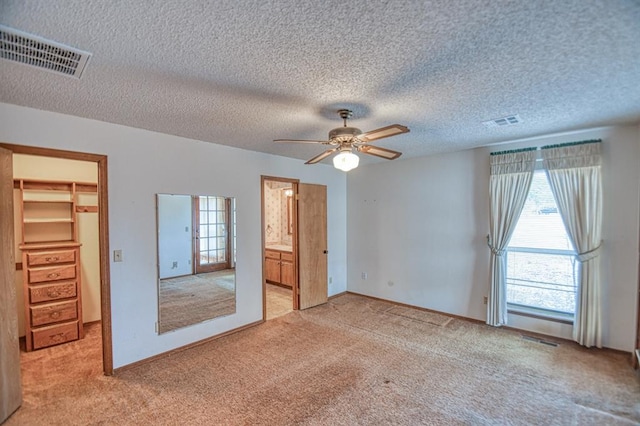 unfurnished bedroom featuring carpet, visible vents, and a textured ceiling