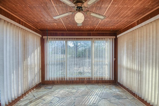 unfurnished sunroom with a wealth of natural light, wood ceiling, and a ceiling fan