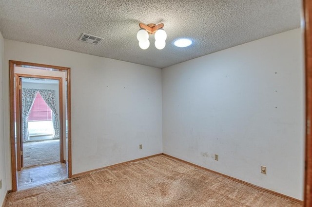 unfurnished room featuring carpet flooring, a textured ceiling, and visible vents