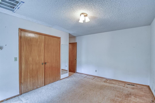 unfurnished bedroom featuring a closet, visible vents, baseboards, and carpet