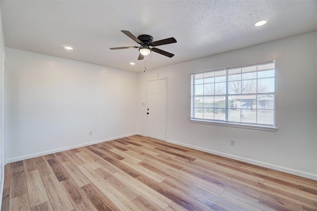 empty room featuring recessed lighting, a textured ceiling, baseboards, and wood finished floors