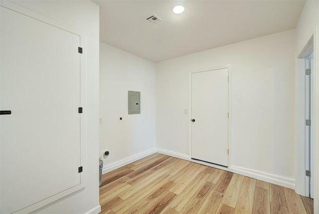 unfurnished room featuring light wood-style flooring, electric panel, visible vents, and baseboards