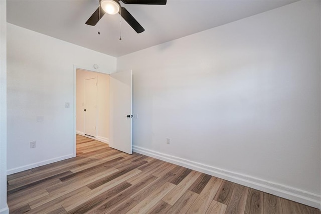 unfurnished room featuring light wood finished floors, ceiling fan, and baseboards