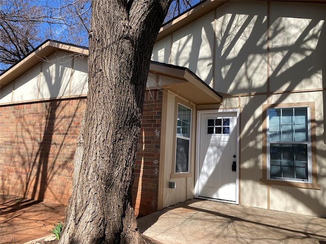 doorway to property featuring brick siding