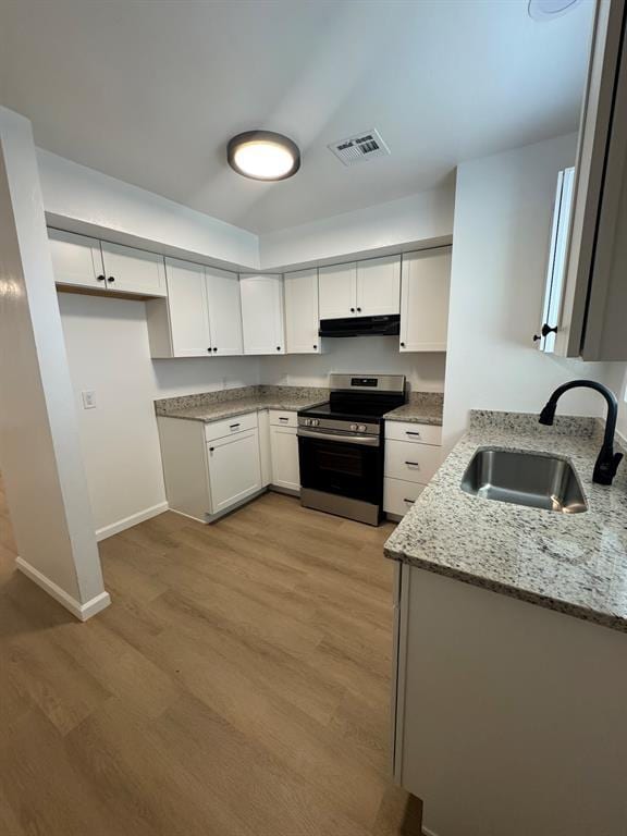 kitchen with visible vents, a sink, light stone countertops, under cabinet range hood, and stainless steel electric range