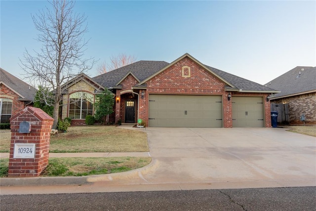 view of front of home with an attached garage, brick siding, a shingled roof, concrete driveway, and a front lawn