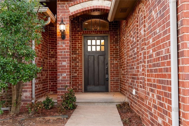 view of exterior entry with brick siding