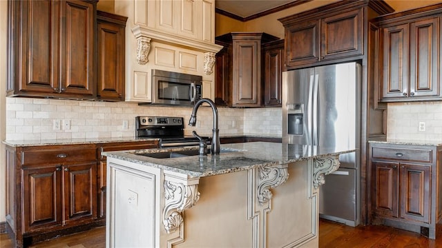 kitchen with dark wood-style floors, a kitchen island with sink, light stone counters, and stainless steel appliances