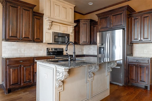 kitchen featuring stainless steel appliances, dark wood-style flooring, stone counters, and an island with sink