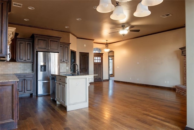 kitchen featuring dishwasher, arched walkways, stainless steel fridge, and visible vents