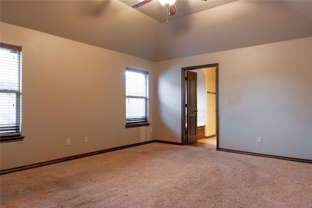 unfurnished room with light carpet, vaulted ceiling, baseboards, and ceiling fan