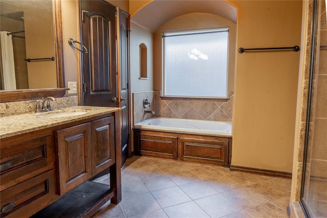 full bathroom featuring tile patterned floors, walk in shower, a bath, and vanity