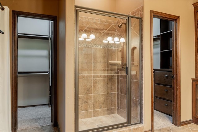 bathroom featuring a spacious closet and a shower stall