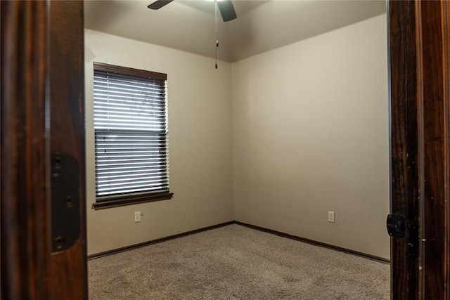 spare room featuring ceiling fan, carpet, and baseboards