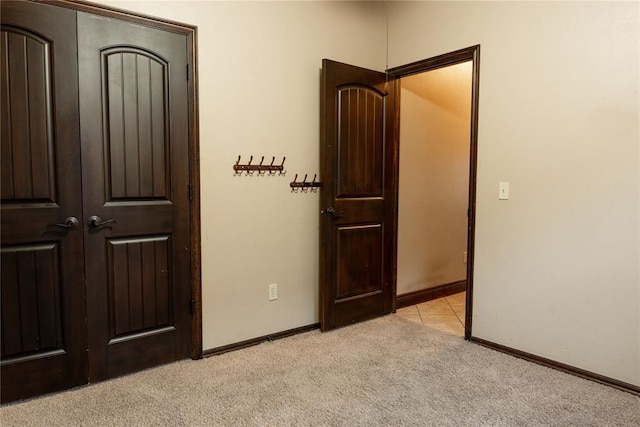 unfurnished bedroom featuring light colored carpet and baseboards