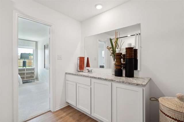 bathroom with wood finished floors, vanity, and baseboards