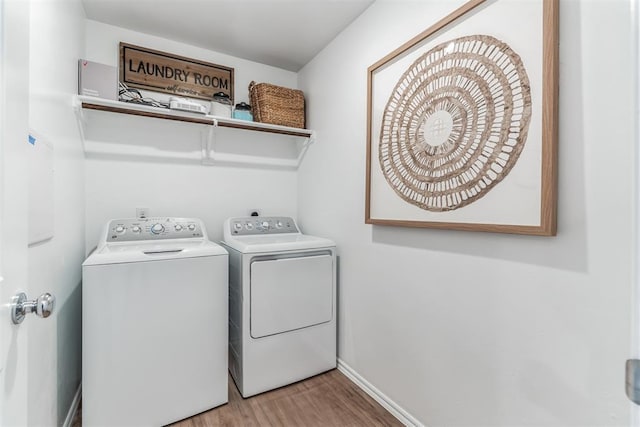 washroom with wood finished floors, laundry area, baseboards, and separate washer and dryer