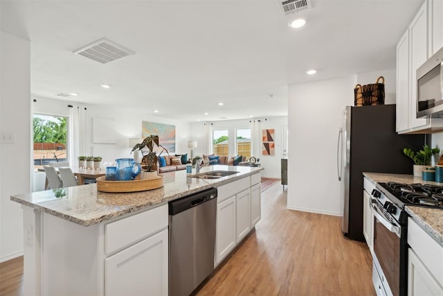 kitchen featuring white cabinetry, visible vents, appliances with stainless steel finishes, and a sink