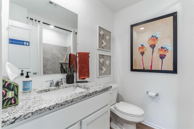 bathroom featuring toilet, vanity, visible vents, and baseboards