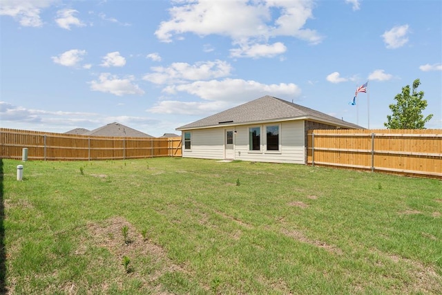 back of house featuring a fenced backyard and a yard