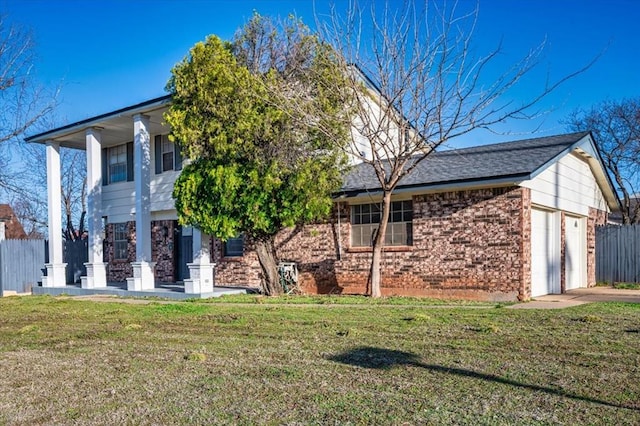 view of front of house with a garage, brick siding, a front yard, and fence