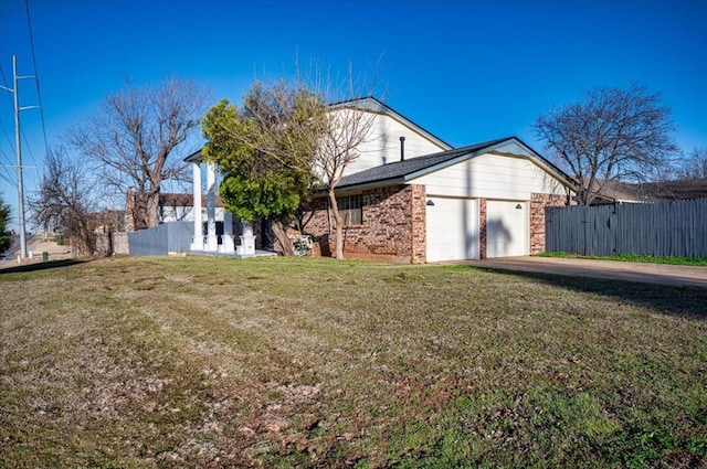 exterior space featuring driveway, an attached garage, a front lawn, and fence