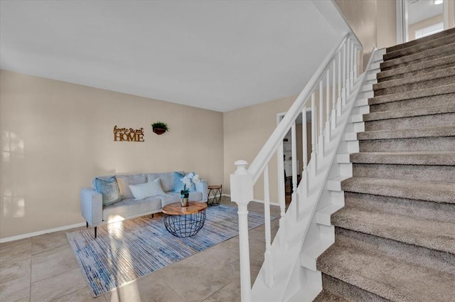 tiled living room featuring stairway and baseboards