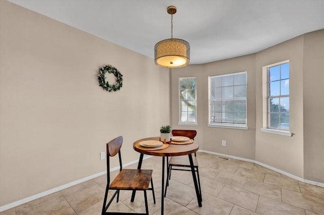 dining room featuring a wealth of natural light, visible vents, baseboards, and light tile patterned floors