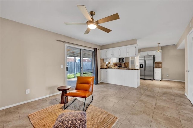 living area featuring light tile patterned flooring, baseboards, and ceiling fan