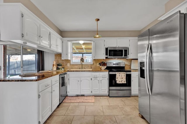 kitchen featuring tasteful backsplash, white cabinetry, dark stone counters, appliances with stainless steel finishes, and light tile patterned flooring