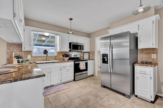 kitchen with white cabinets, appliances with stainless steel finishes, and dark stone countertops