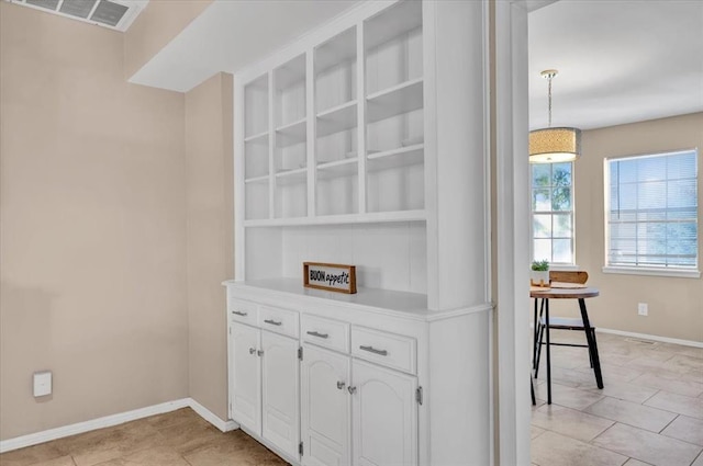 interior space with visible vents, open shelves, white cabinetry, light countertops, and baseboards