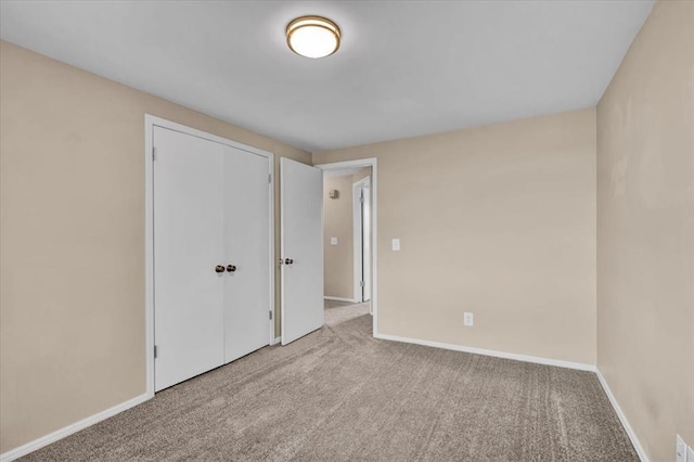 unfurnished bedroom with a closet, baseboards, and carpet floors