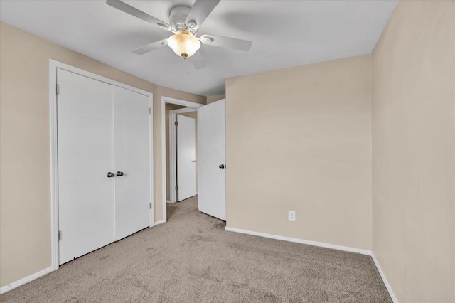 unfurnished bedroom with a closet, baseboards, ceiling fan, and carpet flooring