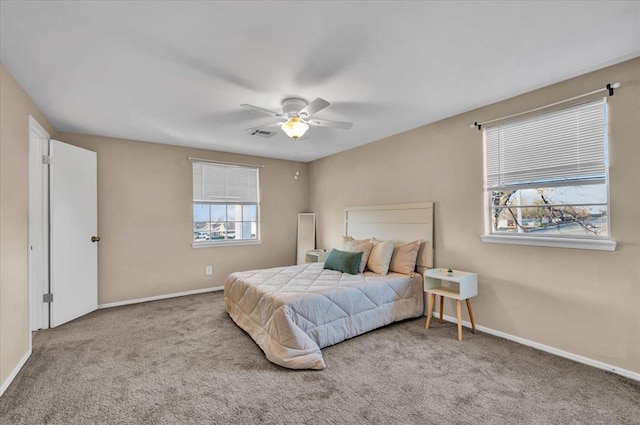 bedroom featuring baseboards, multiple windows, carpet, and a ceiling fan