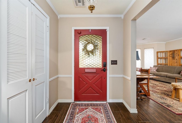 foyer entrance with ornamental molding, baseboards, visible vents, and wood finish floors