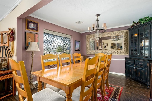 dining area with visible vents, crown molding, baseboards, wood finish floors, and an inviting chandelier