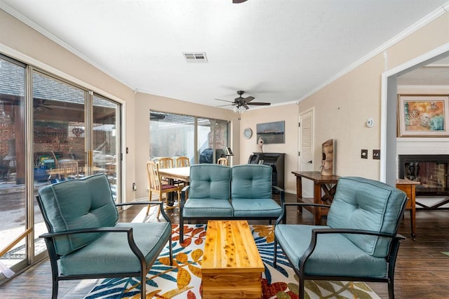 sunroom featuring a fireplace, a ceiling fan, and visible vents