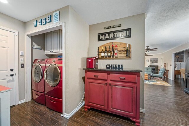 laundry area featuring cabinet space, independent washer and dryer, baseboards, and wood finish floors