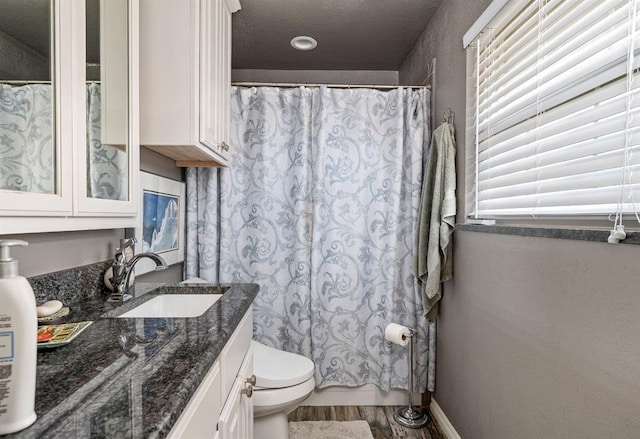 full bathroom with toilet, vanity, and wood finished floors