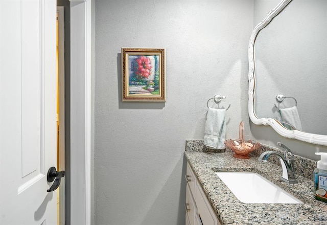 bathroom featuring vanity and a textured wall