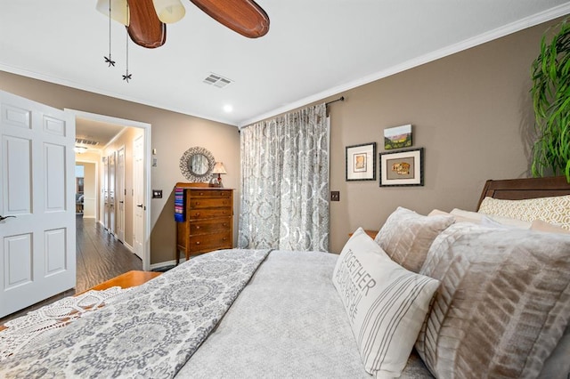 bedroom with visible vents, a ceiling fan, wood finished floors, crown molding, and baseboards