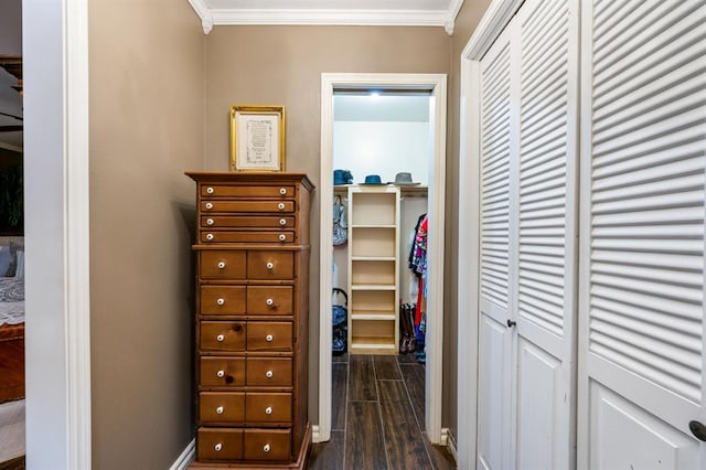 hallway featuring crown molding, baseboards, and wood finish floors