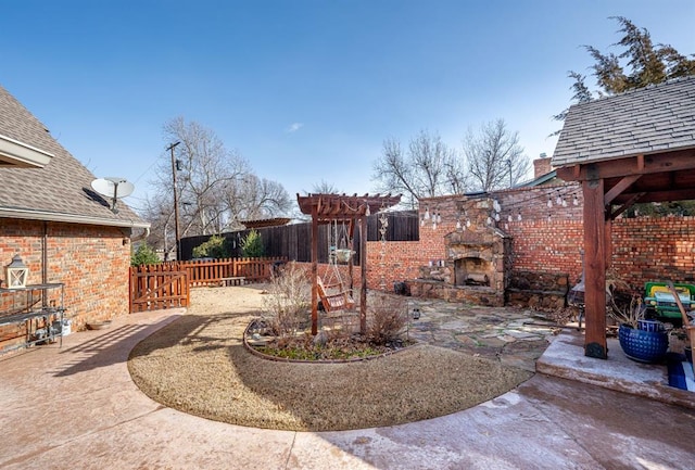 view of yard featuring a patio area, exterior fireplace, and fence