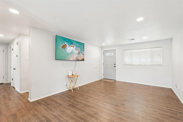 foyer featuring baseboards, visible vents, wood finished floors, and recessed lighting