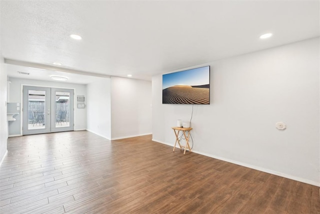 unfurnished living room featuring recessed lighting, baseboards, wood finished floors, and french doors