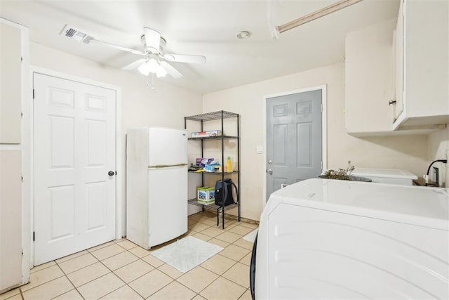 laundry area featuring light tile patterned floors, washing machine and dryer, visible vents, a ceiling fan, and cabinet space