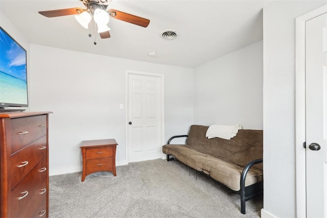 living area with light carpet, ceiling fan, visible vents, and baseboards