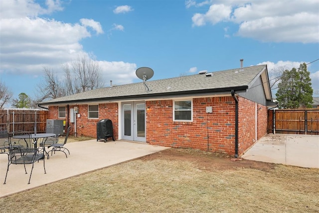 back of property with cooling unit, a patio area, brick siding, and a fenced backyard